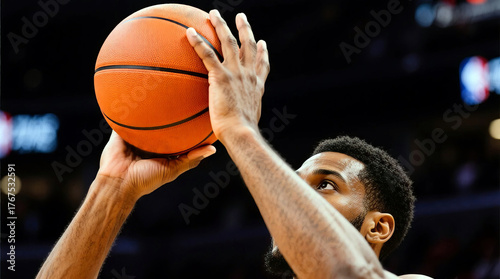 African American man preparing to shoot a basketball, showcasing focused expression and athletic stance, with blurred crowd in background highlighting competitive sports atmosphere