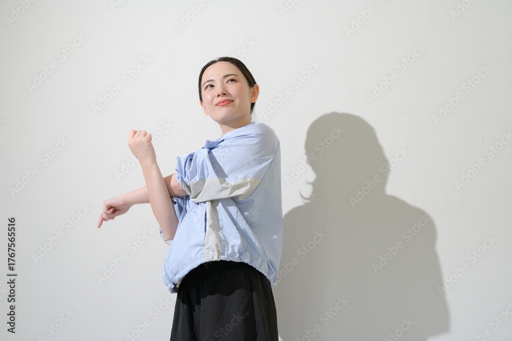 Fototapeta premium 白背景でストレッチをする日本人女性