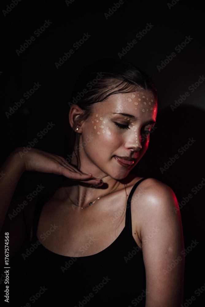 Naklejka premium Portrait of a girl on a dark background. Makeup.