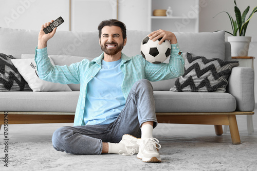 Young man with TV remote co...