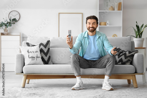 Young man with TV remote co...