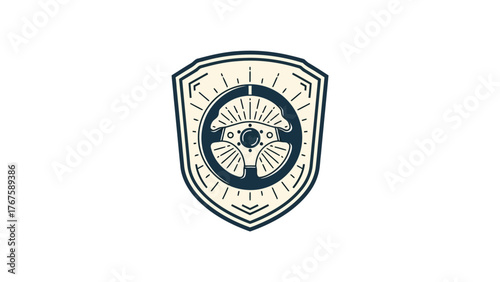 A geometric emblem featuring a stylized wheel and rays in a shield-shaped frame