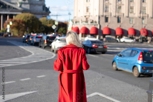 Obraz na plátně Stylish blonde hair woman in red coat walking on the street