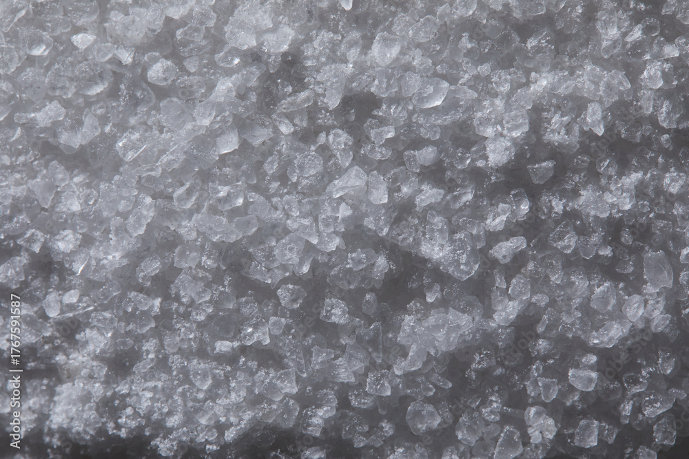 Fototapeta premium Coarse gray salt crystals forming a textured background, showing mineral structure and organic crystalline pattern