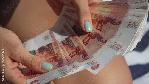 Money counting hands, woman counting Russian ruble banknotes outdoors, showing finance wealth