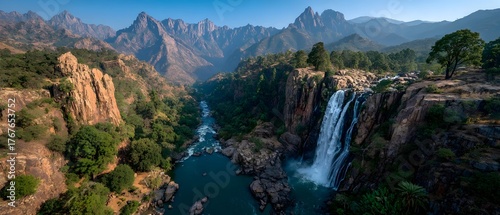 A waterfall is in the foreground of a mountain range