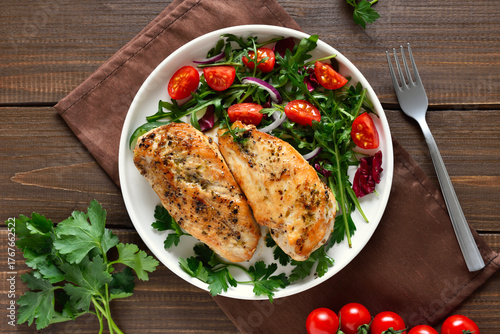 Baked chicken breast and vegetable salad on plate