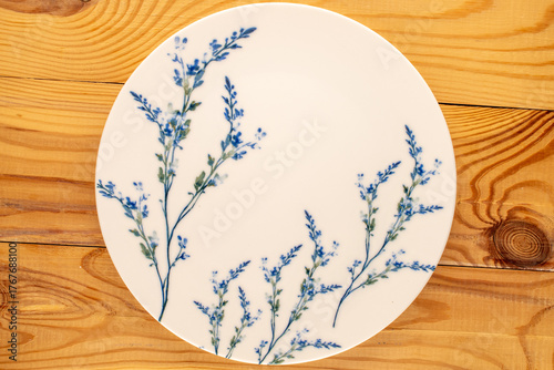 Ceramic plate on a wooden table, top view.