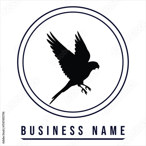 Black bird silhouette flying inside circle falcon hawk