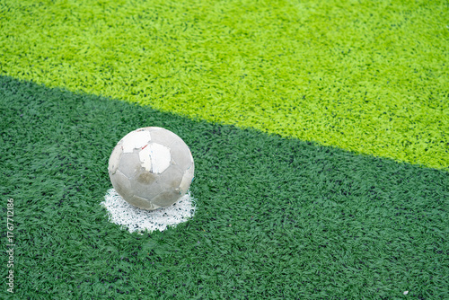 an old soccer on the penalty spot on a soccer field at horizontal composition
