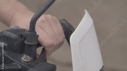 A girl on a motorcycle. A girl sits on an adventure motorcycle during the day, squeezing the clutch lever.