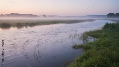Misty River Landscape at Dawn with Soft Pink and Blue Sky Over Green Grassy Banks