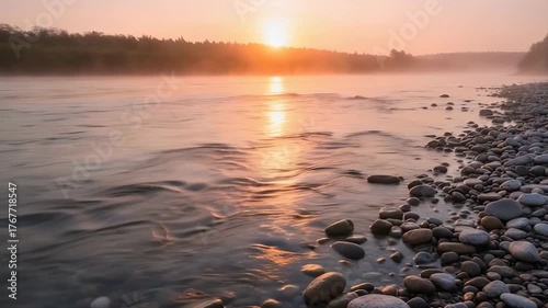 Misty River Sunrise With Golden Light Reflecting On Rippling Water And Rocky Shoreline With Green Forest In The Background
