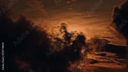 silhouette of a man walking in the mountains aerial shot above beautiful sunset clouds with sun shining through fog, detailed picturesque view, camera moving into amazing cloudscape with beautiful