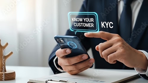 Close Up of Man in Suit Using Smartphone with Holographic Know Your Customer Concept Over White Desk with Clipboard and Decorative Wooden Sculpture