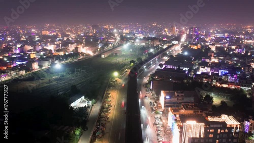 Aerial drone hyper time lapse showing Indian city on diwali night with traffic passing by decorated buildings and fireworks on the horizon showing the celebration of this hindu festival of light
