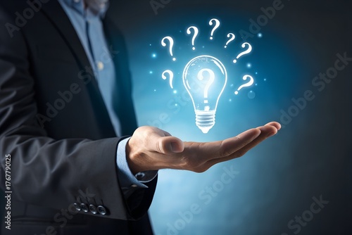 Businessman holding glowing lightbulb and question mark with copy space for creative thinking idea and problem solving concept.