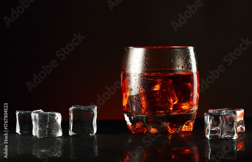 a glass of alcohol and ice cubes