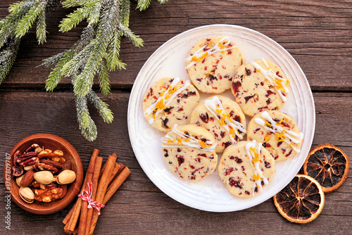 Christmas holiday cranberry orange icebox cookies. Top down view table scene on a dark wood background.