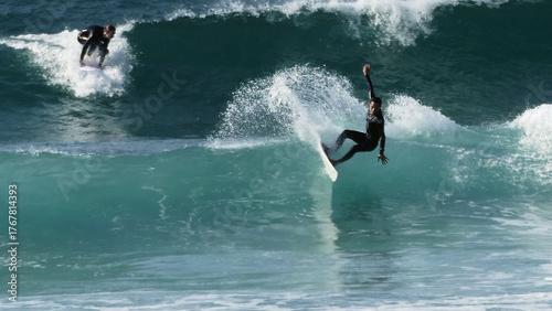 Surfer catching a perfect wave at Godrevy Beach, Cornwall. The surfer is perfectly balanced on the edge of the break