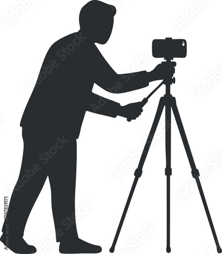 Silhouette of a photographer adjusting a camera on a tripod for a photo shoot.