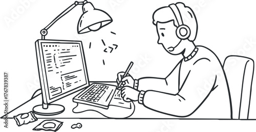 A man working at a desk with a computer and headphones, focused on his tasks.