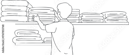 A man organizing towels on shelves in a retail store showcasing neat arrangement and cleanliness.