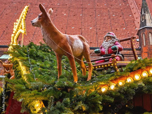 Santa figurine on a sleigh with a reindeer on a roof at Christmas market. Hannover, Germany