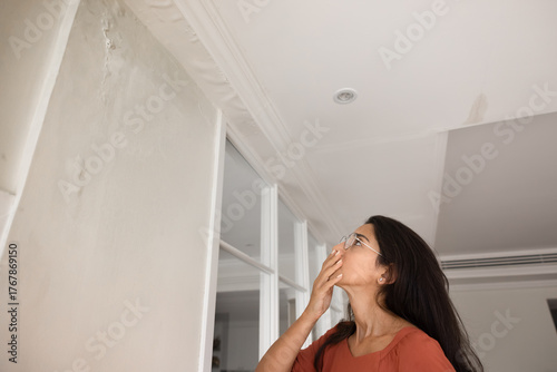 Photography Shocked Latin homeowner woman inspecting apartment with damaged decoration