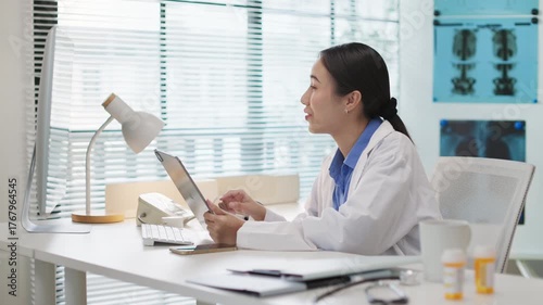 Asian female doctor doing online consultation, remote healthcare, virtual medical advice to patient via video call in hospital or clinic. Telemedicine, digital healthcare services, online diagnosis