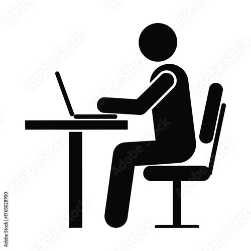Silhouette of a person working on a laptop at a desk