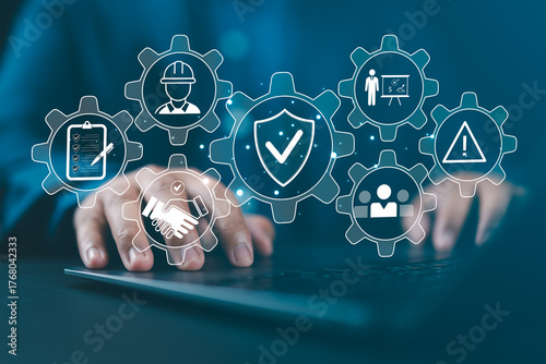 Work Safety and Compliance Concept. Man typing on a laptop with icons work safety, compliance, risk management, operational efficiency, health protocols, workplace regulatory, and safety standards.