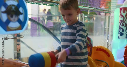 Child Playing Whack-a-Mole Game at Indoor Arcade
