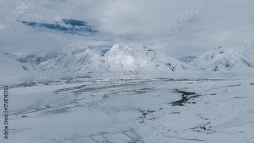 Stunning aerial drone view of the vast, towering snow-covered Himalayan mountain ranges in Ladakh, India.