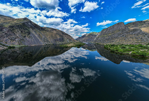 Drone photo of calm surface of Snake river, Hells Cayon. Clouds reflection in blue water