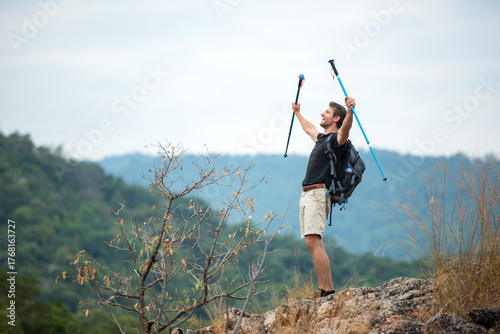 Hiker man backpack raise hands and walking trail activity camping outdoors for destination leisure.  People happy feeling freedom good and strong weight victorious facing on the natural mountain