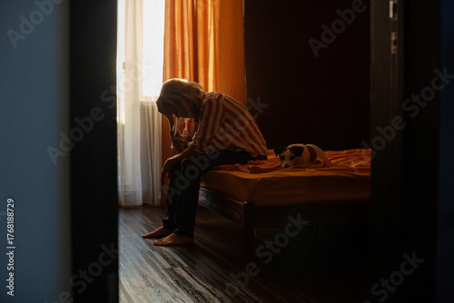 Lonely young Woman feeling Depressed and Stressed sitting head in hands in the dark bedroom