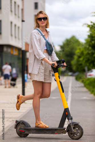 woman riding on electric scooter on city street