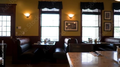 Cozy restaurant booths with warm lighting and tables set for dining