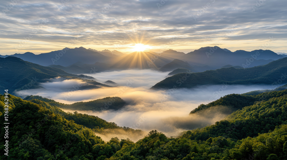 Obraz premium Golden sunlight breaks through clouds over misty mountain valley, creating serene atmosphere