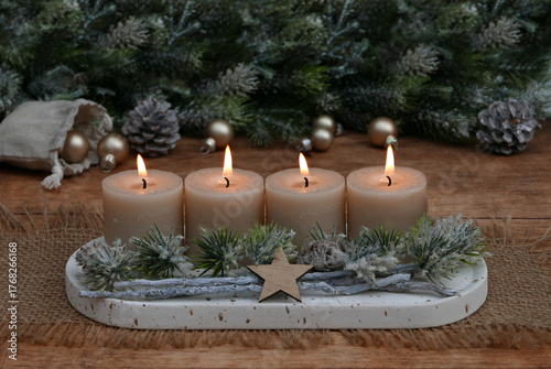  Arrangement für den vierten Advent : Dekoration mit vier beigen Adventskerzen, Tannenzweigen und Weihnachtskugeln.