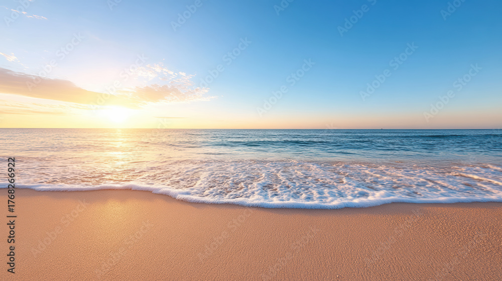 Fototapeta premium Gentle ocean waves wash over soft sandy beach at sunrise, creating serene atmosphere