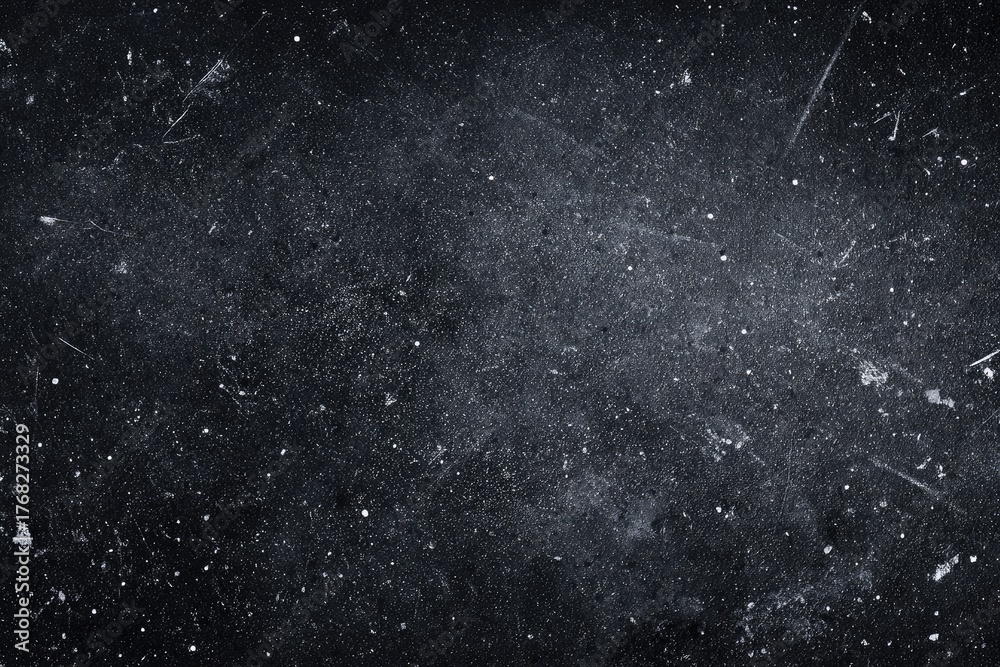 Fototapeta premium Grungy black surface speckled with light particles, and distressed with scratches