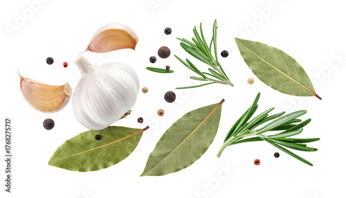 Garlic cloves, bay leaves, rosemary sprigs, and peppercorns scattered randomly on clean white background
