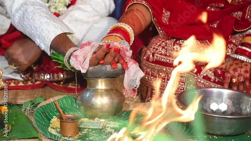 Hands of the bride and groom in wedding Ceremony. Hindu wedding ritual. Odia Wedding. Hindu Wedding Ceremony with Burning Fire and Offering Ritual with People and Golden Details.