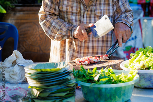 A man grills pork in a crispy, fragrant pot at a party. The crispy pork chops are a popular dish in Thailand.