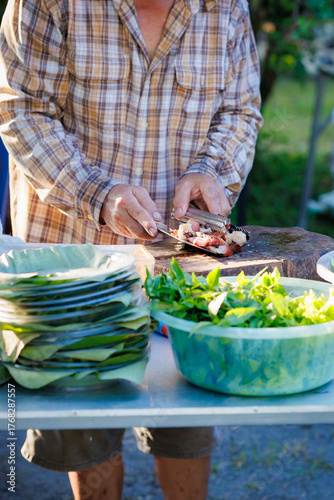 A man grills pork in a crispy, fragrant pot at a party. The crispy pork chops are a popular dish in Thailand.