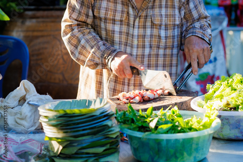 A man grills pork in a crispy, fragrant pot at a party. The crispy pork chops are a popular dish in Thailand.
