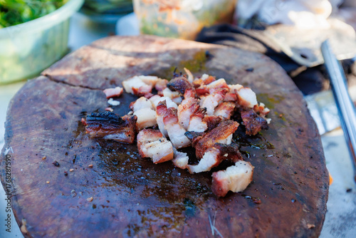 A man grills pork in a crispy, fragrant pot at a party. The crispy pork chops are a popular dish in Thailand.
