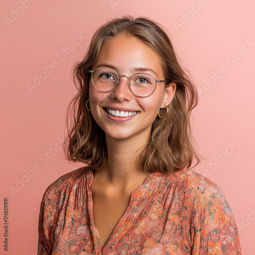 portrait of a young woman in glasses on pastel cream-pink background
